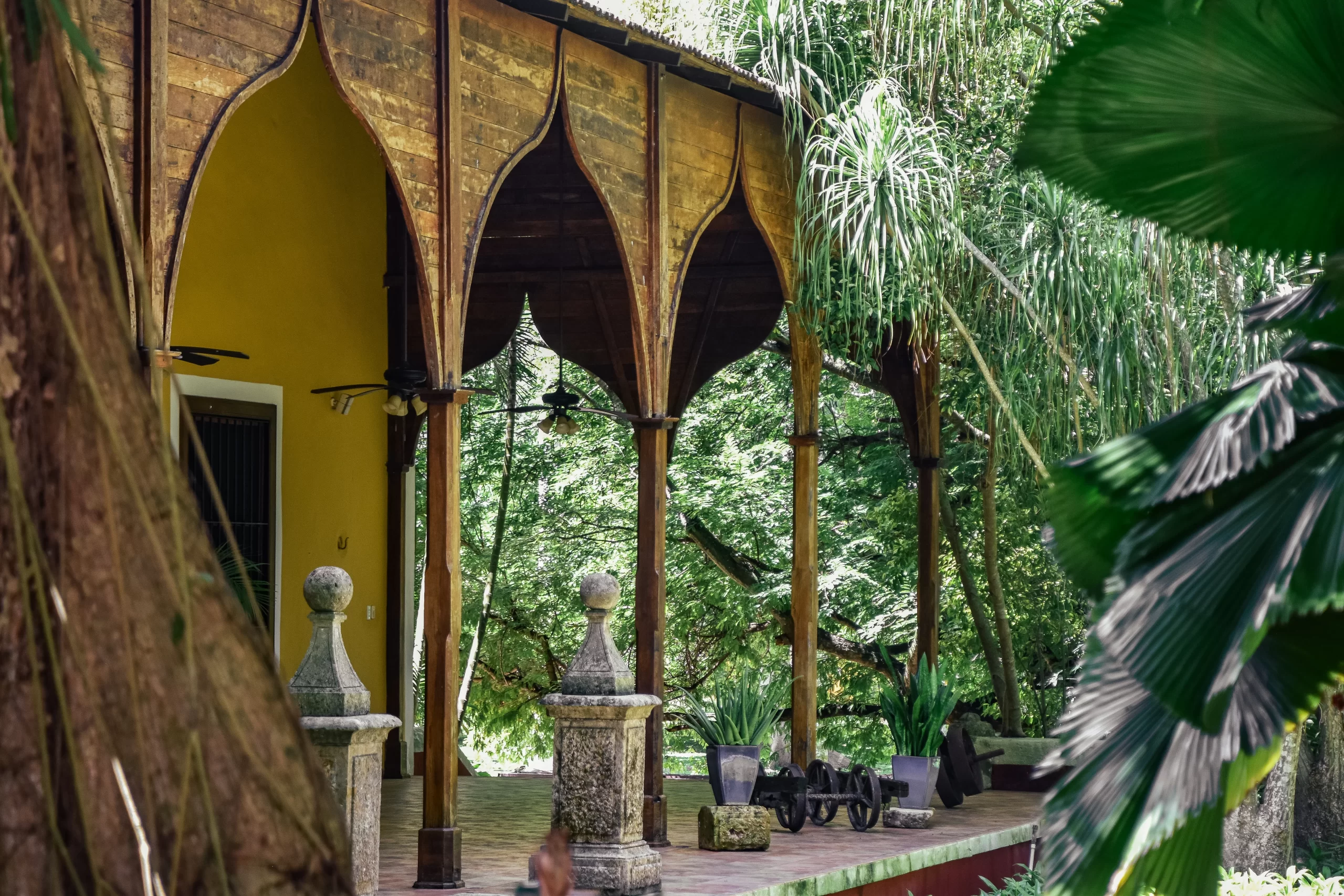 Fachada de Hacienda Chuntuac con columnas y palmas reales